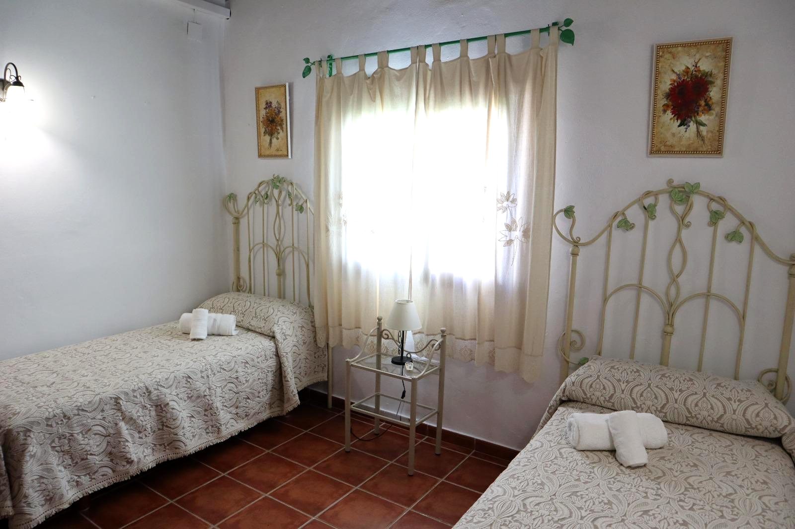 Dormitorio con dos camas individuales y cabeceros de forja
